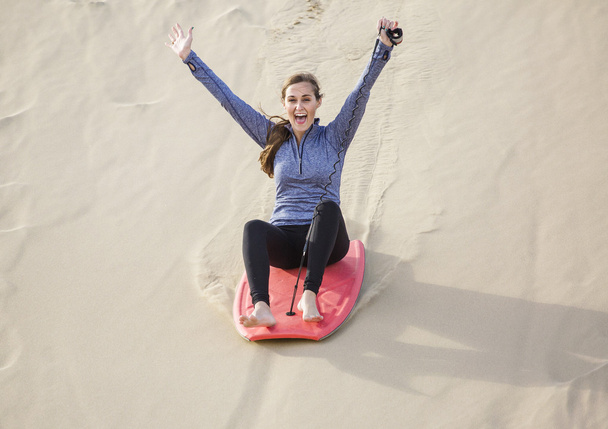 女性、砂丘をボードに乗って  - 写真・画像