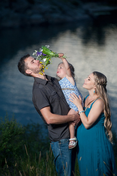 Father, daughter and pregnant mother having fun outdoors. Happy family. - Photo, Image