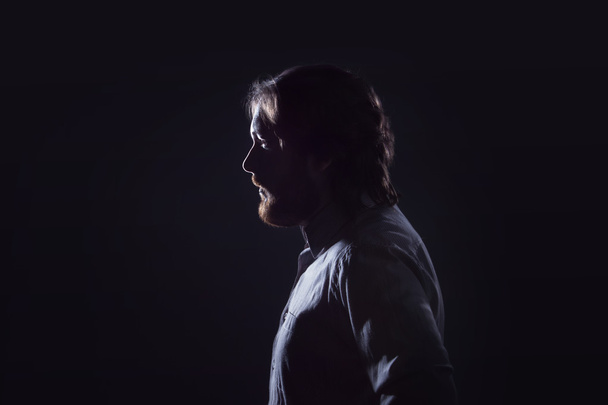 Man with  beard, profile  on  dark background, the silhouette. - Foto, afbeelding