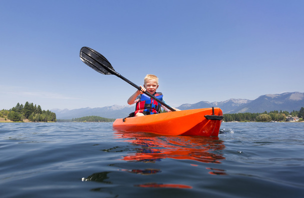 Giovane ragazzo remare un kayak
  - Foto, immagini