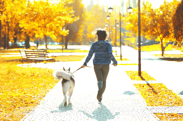 Woman jogging with her dog in park - Φωτογραφία, εικόνα