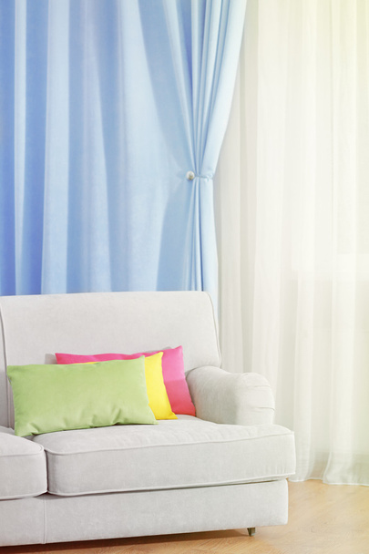 Sofá no quarto com cortinas
 - Foto, Imagem