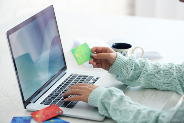 Concepto de comercio electrónico. Mujer con tarjeta de crédito, portátil y taza de café, de cerca
 - Foto, Imagen