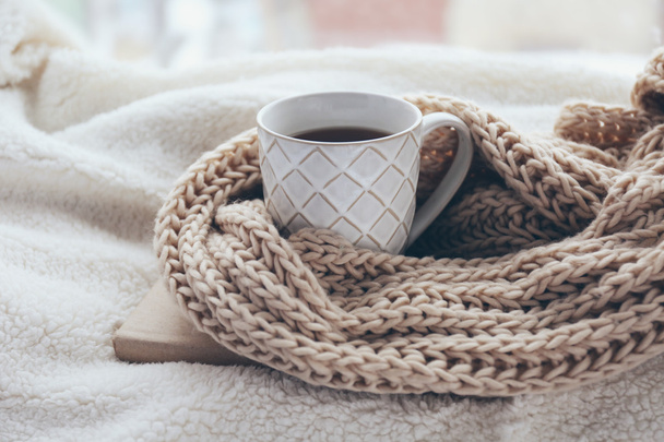 Cup of tea and warm knitted scarf - 写真・画像