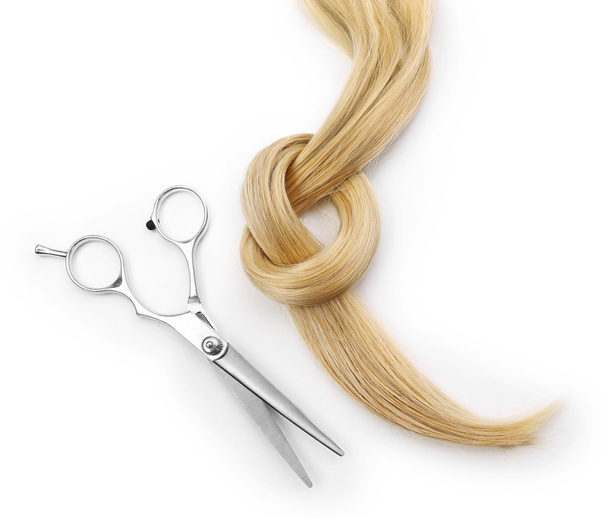 scissors with strand of blonde hair  - Fotó, kép