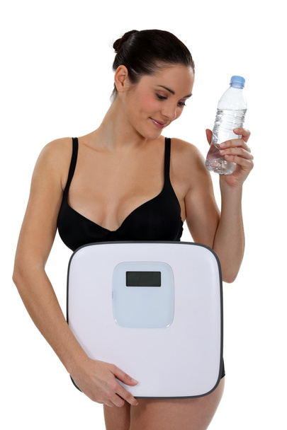 Woman with bottle of water and scales - Fotoğraf, Görsel
