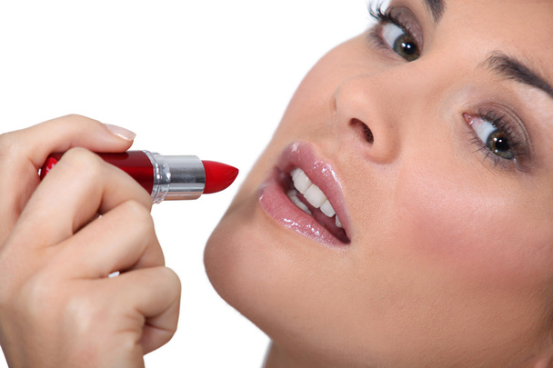 Woman applying lipstick - Foto, Imagen