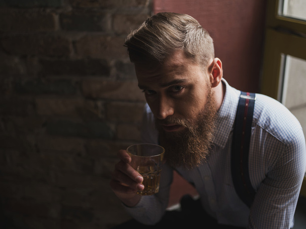 Attractive young businessman is enjoying alcohol drink - Foto, immagini