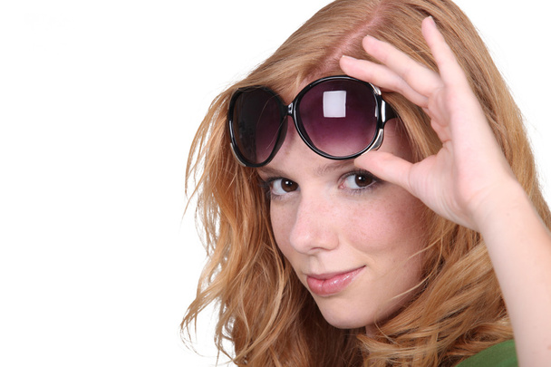Studio closeup of young beautiful redhead with big sunglasses - Zdjęcie, obraz
