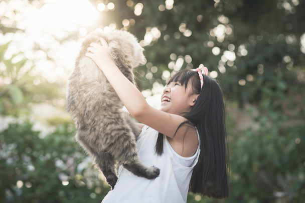 Азіатський дівчинка тримає Lovely персидський кіт  - Фото, зображення