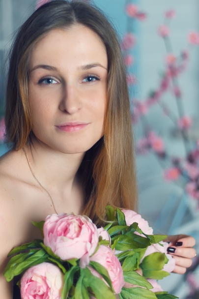 Beautiful close-up portrait of a young woman with peonies - Foto, afbeelding