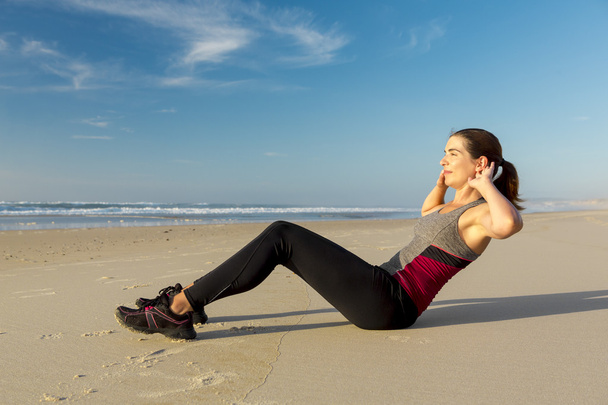 Woman working her ABS in the beach - Foto, Imagem