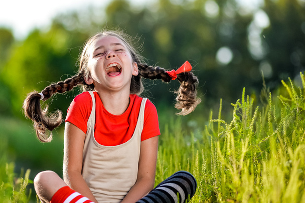 niegrzeczna dziewczynka z warkoczykami, otwiera swoje usta i krzyczy - Zdjęcie, obraz