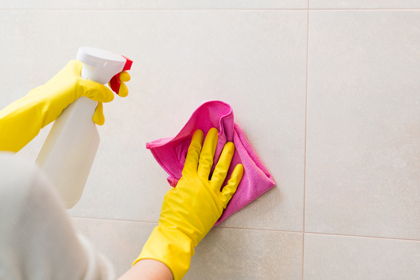 cleaning tiles in bathroom with pink cloth - Foto, Imagem