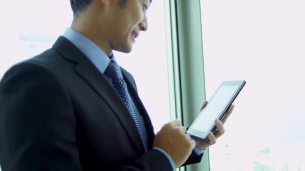 Asijské podnikatel pomocí bezdrátové tablet - Záběry, video