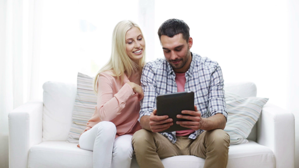 ευτυχισμένο ζευγάρι με tablet pc, προβολή φωτογραφιών στο σπίτι - Πλάνα, βίντεο