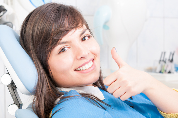 Close-up de morena paciente do sexo feminino sorrindo e mostrando o polegar para cima
 - Foto, Imagem