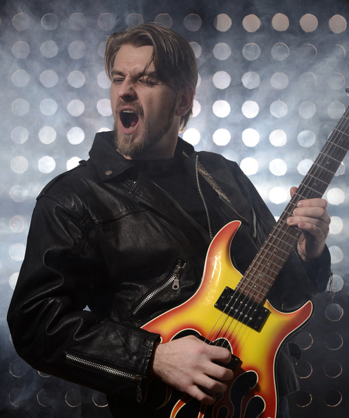 ροκ κιθαρίστας παίζει ηλεκτρική κιθάρα σε ομίχλη - Φωτογραφία, εικόνα
