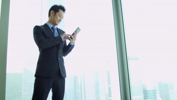 Azjatycki biznesmen za pomocą bezprzewodowej tabletki - Materiał filmowy, wideo