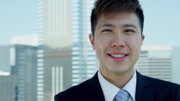 young Asian businessman standing on rooftop - Felvétel, videó