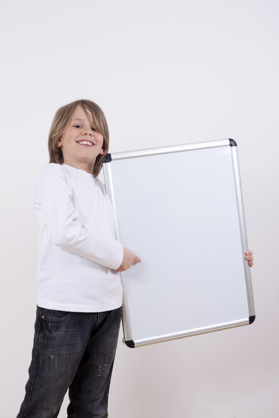 Niño sosteniendo tablero de dibujo blanco
. - Foto, Imagen