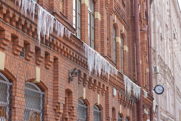Old clock and Icicles on a brick wal - Foto, Imagem