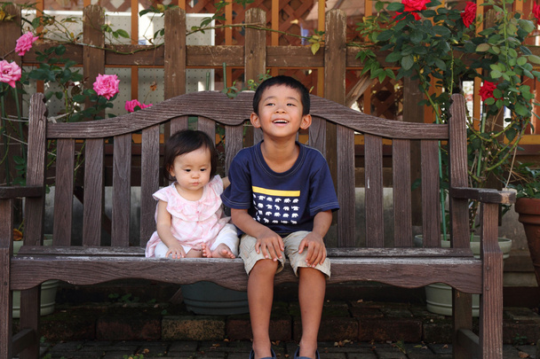 Japonské bratr a sestra (5 let a 0 let staré) sedí na lavičce - Fotografie, Obrázek