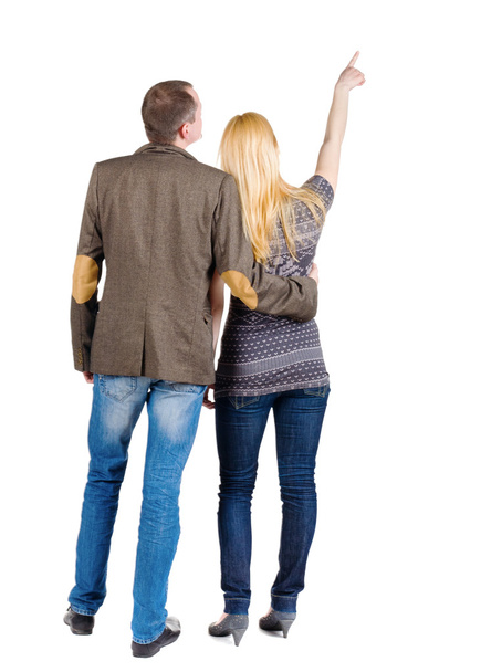 Back view of young couple pointing at wall. - Фото, зображення