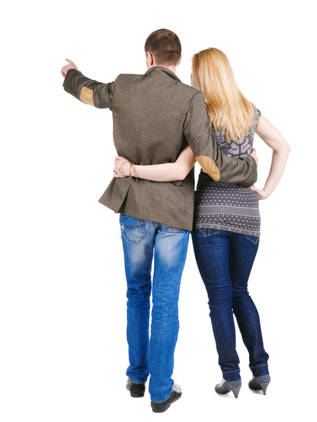 Back view of young couple pointing at wall. - Foto, Imagem