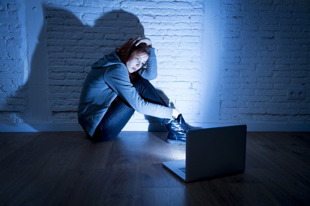 サイバーいじめや嫌がらせに苦しむコンピュータラップトップを持つ怖い女性のティーンエイジャーは、オンライン虐待されています - 写真・画像