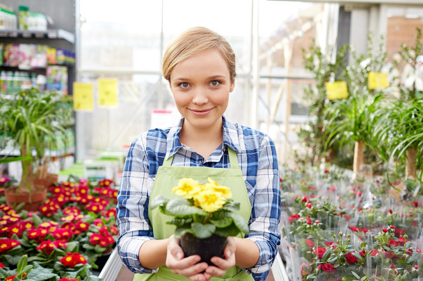 happy woman holding flowers in greenhouse or shop - Foto, Imagem