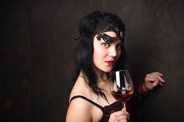 beautiful brunette woman holding a glass of red wine - Фото, изображение