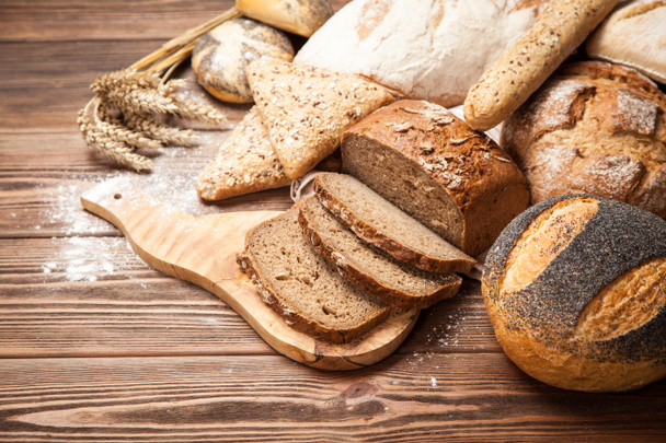 Ассортимент хлеба на деревянной поверхности
 - Фото, изображение