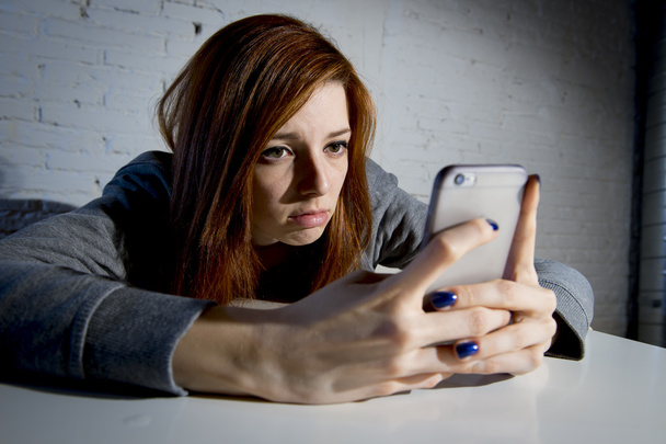 nuori surullinen haavoittuva tyttö käyttää matkapuhelinta peloissaan ja epätoivoinen kärsimystä verkossa väärinkäyttö verkkokiusaaminen
 - Valokuva, kuva