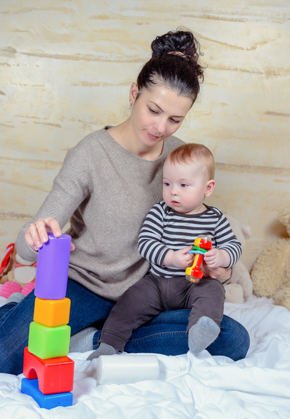 Mamma e bambino giocando blocchi di plastica a casa
 - Foto, immagini