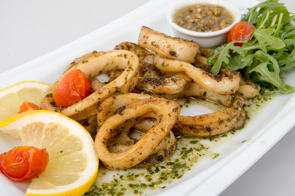Seasoned calamari with lemon, tomatoes and spices. - Photo, Image
