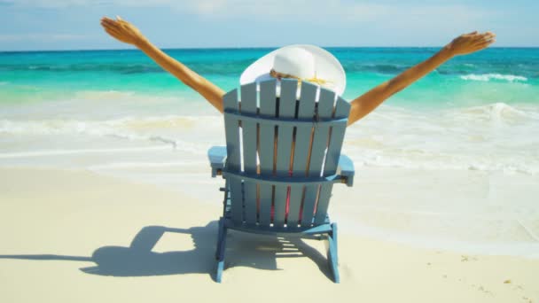 tropik sahilde ahşap sandalye üzerinde güneşlenme kız  - Video, Çekim