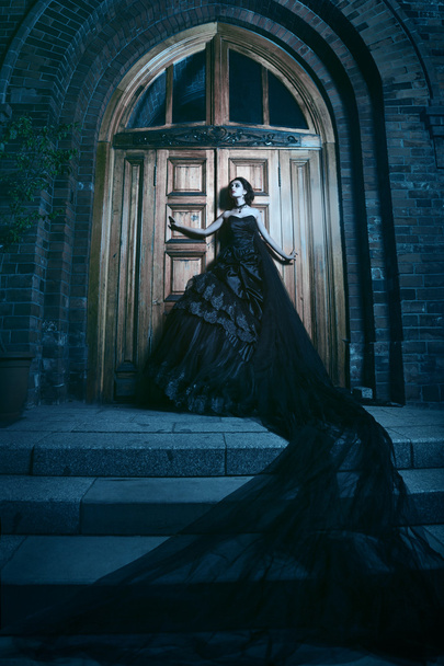 Mysterious woman in black dress near chirch - Фото, зображення