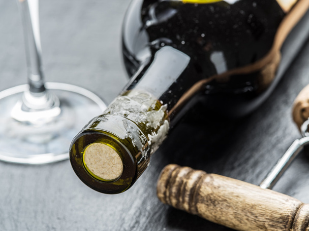 Weinflasche, Weinglas und Korkenzieher auf der Graphitplatte. - Foto, Bild