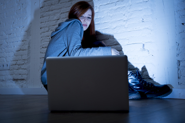 напуганная девушка-подросток с компьютером ноутбук страдает киберзапугивания и преследования в Интернете злоупотреблений
 - Фото, изображение