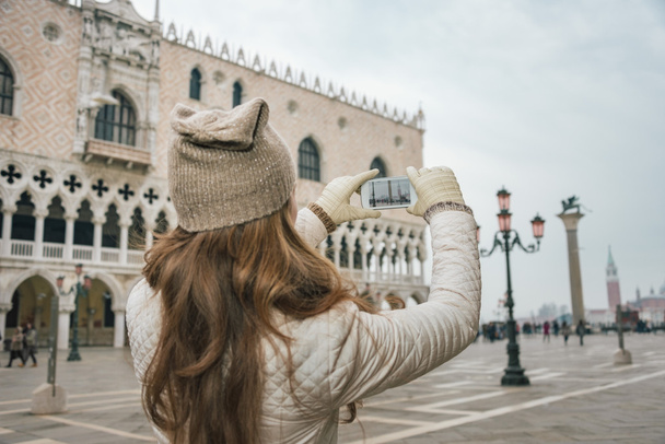Visto da dietro donna turista scattare foto in Piazza San Marco
 - Foto, immagini