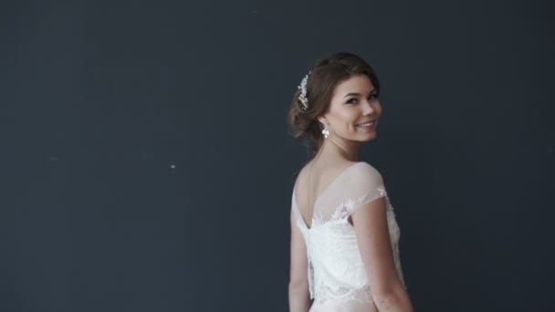 Beautiful young bride in white wedding dress spinning. girl smiling - Záběry, video