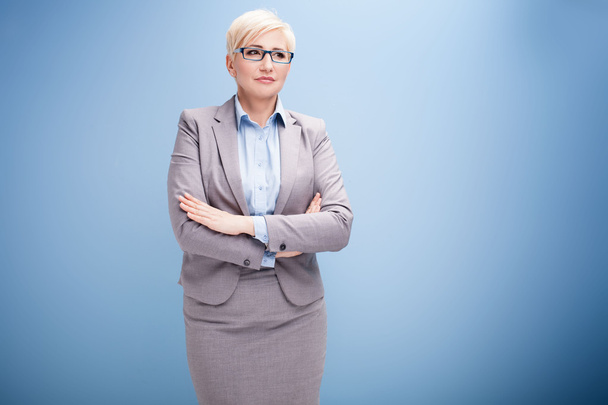 Blonde businesswoman on blue background. - Foto, imagen