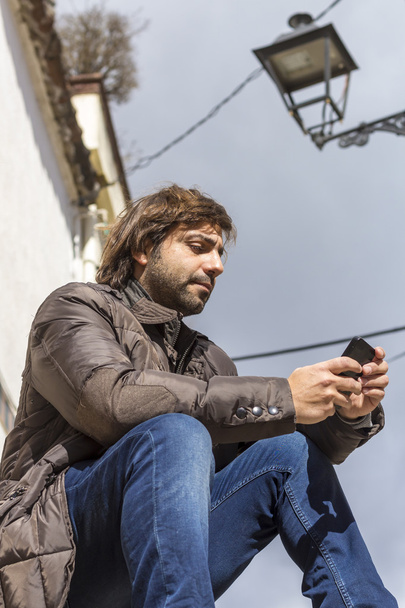 Homme assis sur les marches regardant le téléphone mobile
 - Photo, image