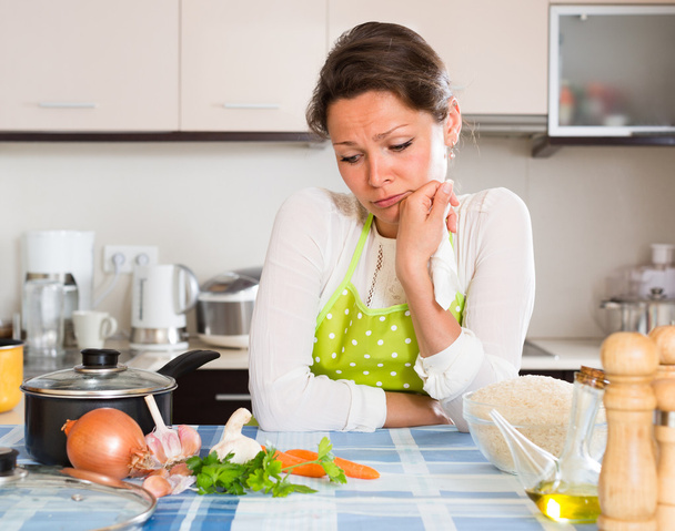 Vrouw kookt rijst in de keuken - Foto, afbeelding