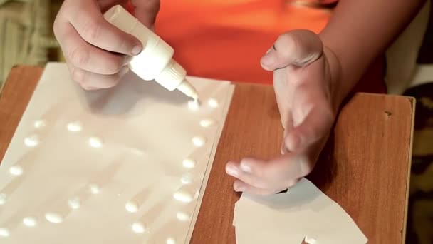 A gyermek csöpög egy tiszta papírlapra ragasztó - Felvétel, videó