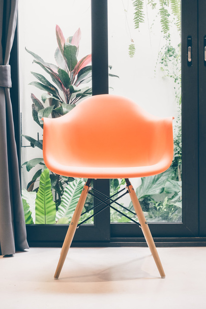 Orangener Stuhl mit Lampe - Foto, Bild