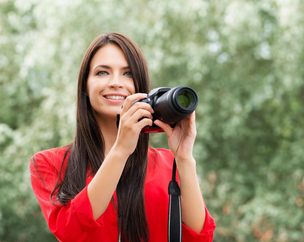 Young beautiful brunette being happy with new slr photo camera - Foto, imagen