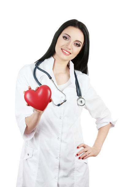 Young beautiful doctor with stethoscope holding heart isolated on white - 写真・画像