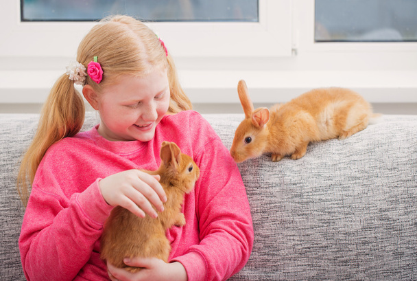 smiling girl with two rabbits indoor - Φωτογραφία, εικόνα